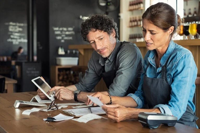 Two individuals looking at receipts